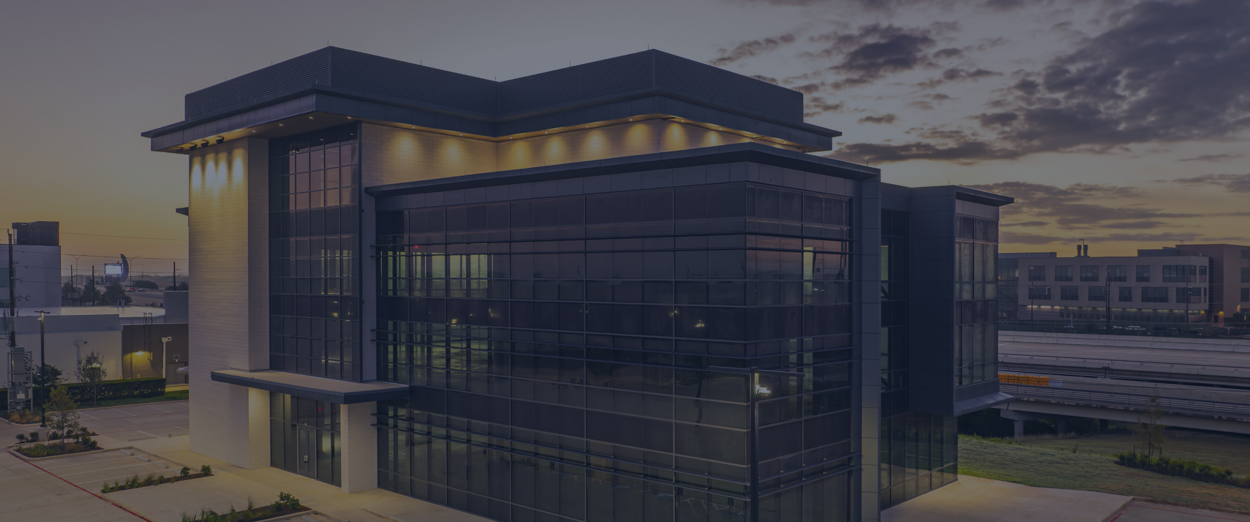 Modern glass building at sunset with messaging about Modisoft's vision and business growth.