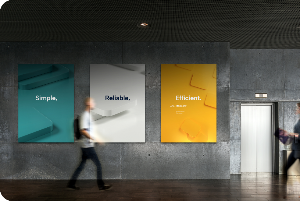 Modern office interior with posters displaying Modisoft values, Simple, Reliable, and Efficient, creating a professional environment that reflects company branding.